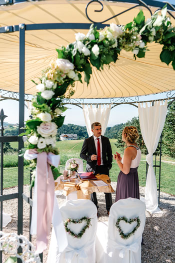 Arreglos de mesa, moño floral y arco de flores en una boda libre.